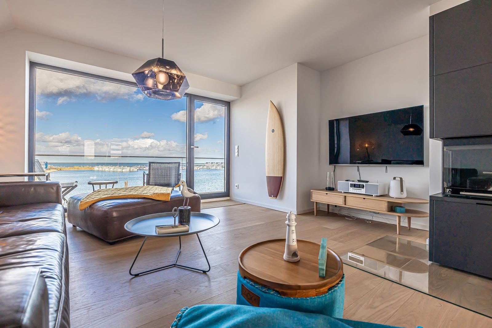 Wohnzimmer mit Meerblick, Sofa, Couchtisch und Fernseher.