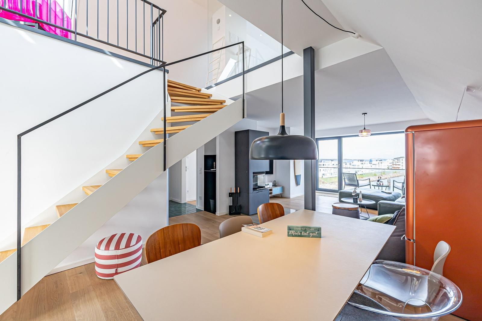Moderne Küche mit Essbereich und Treppe zur oberen Etage.