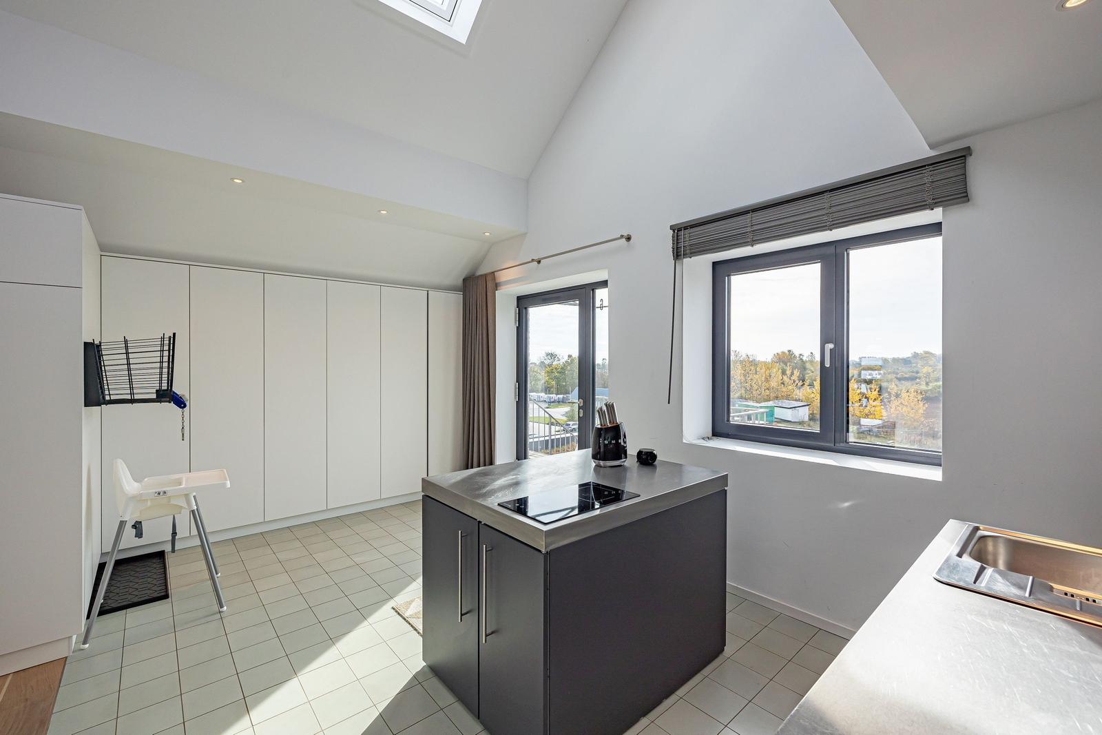 Moderne Küche mit Essbereich, Fenster und Dachfenster. Hochwertige Einrichtung.