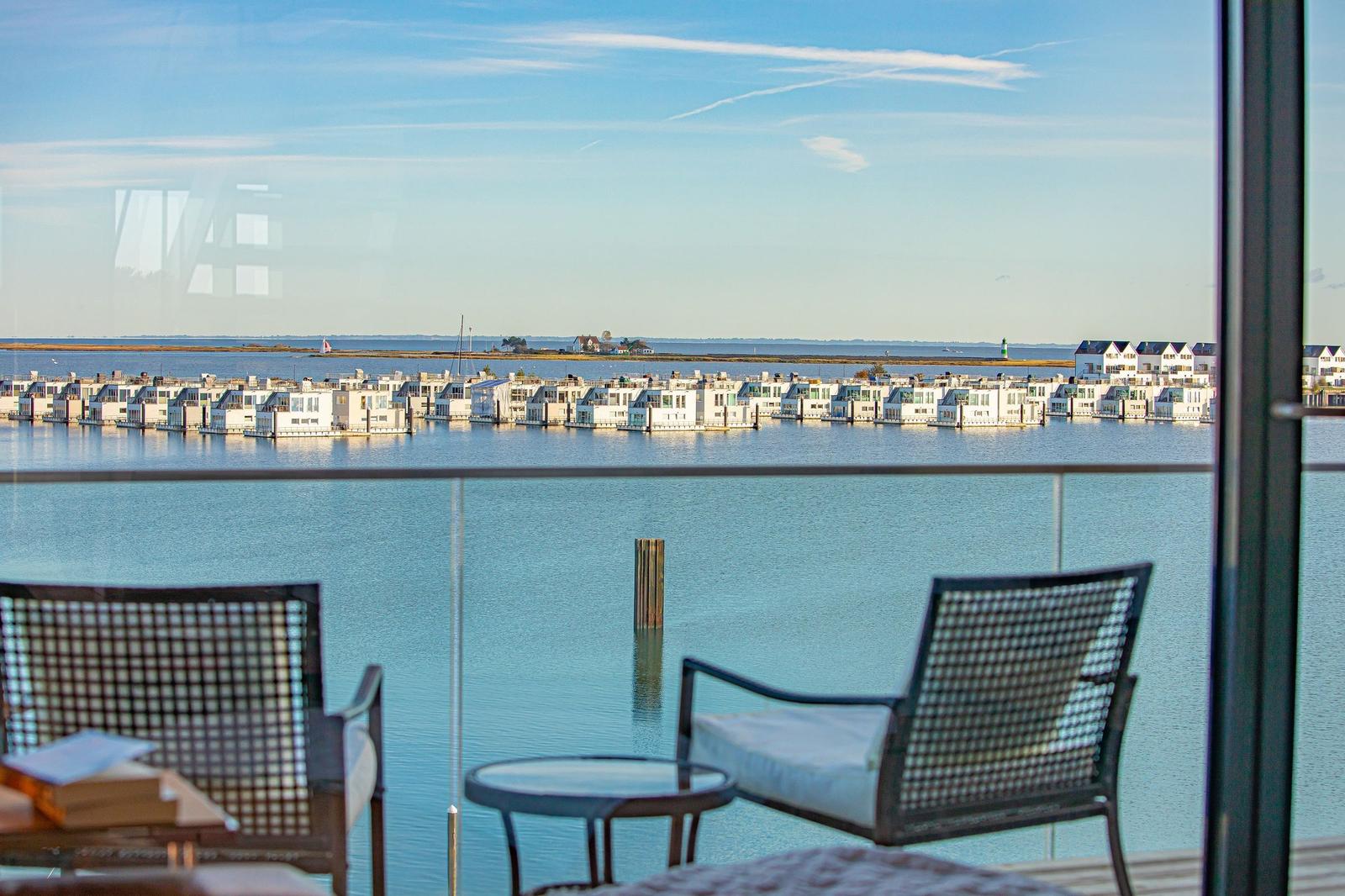 Balkon mit Sitzgelegenheiten und Blick auf Wasser und Häuser