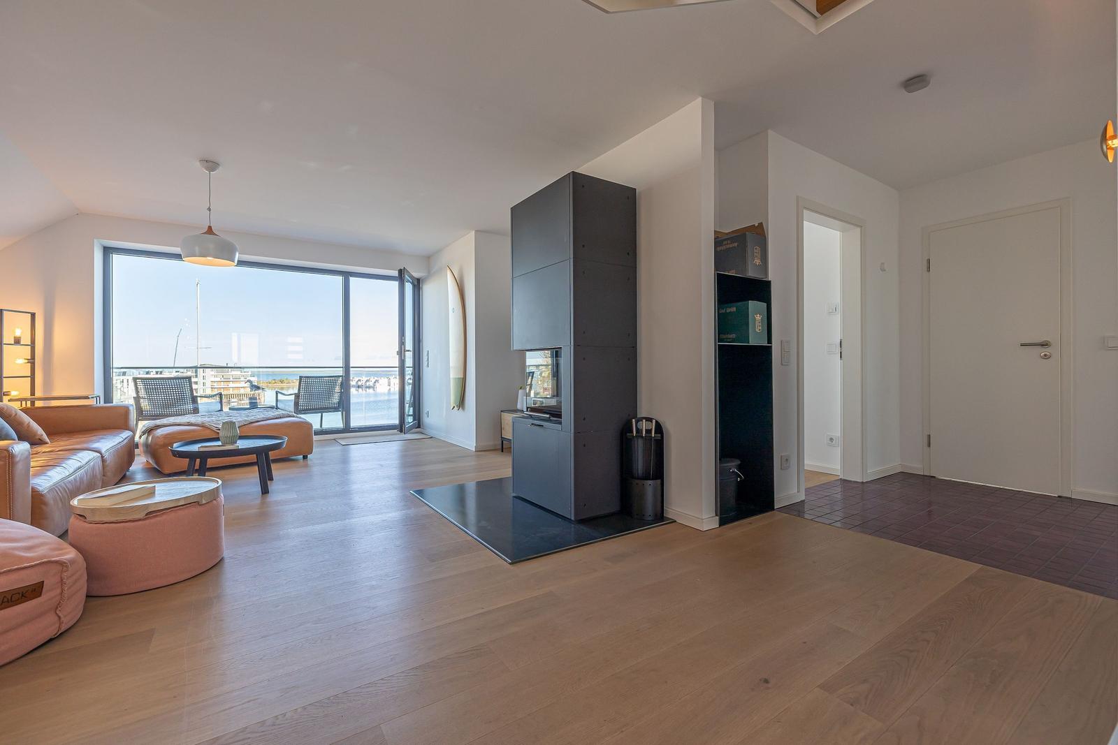 Wohnzimmer mit Blick auf Hafen, Holzboden und moderner Einrichtung.