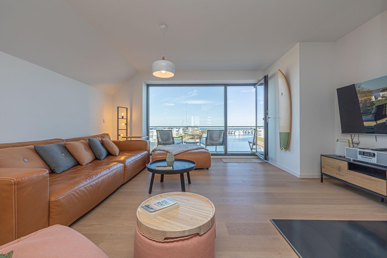 Wohnzimmer mit Sofa, Couchtisch und Blick auf Hafen.