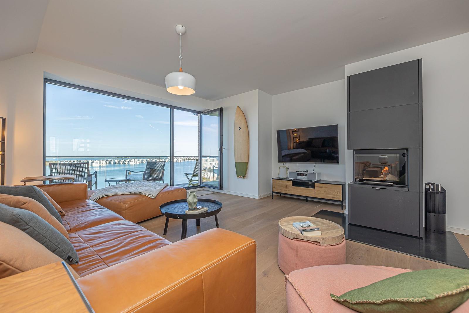 Wohnzimmer mit Blick auf Hafen, Sofa, Kamin und TV