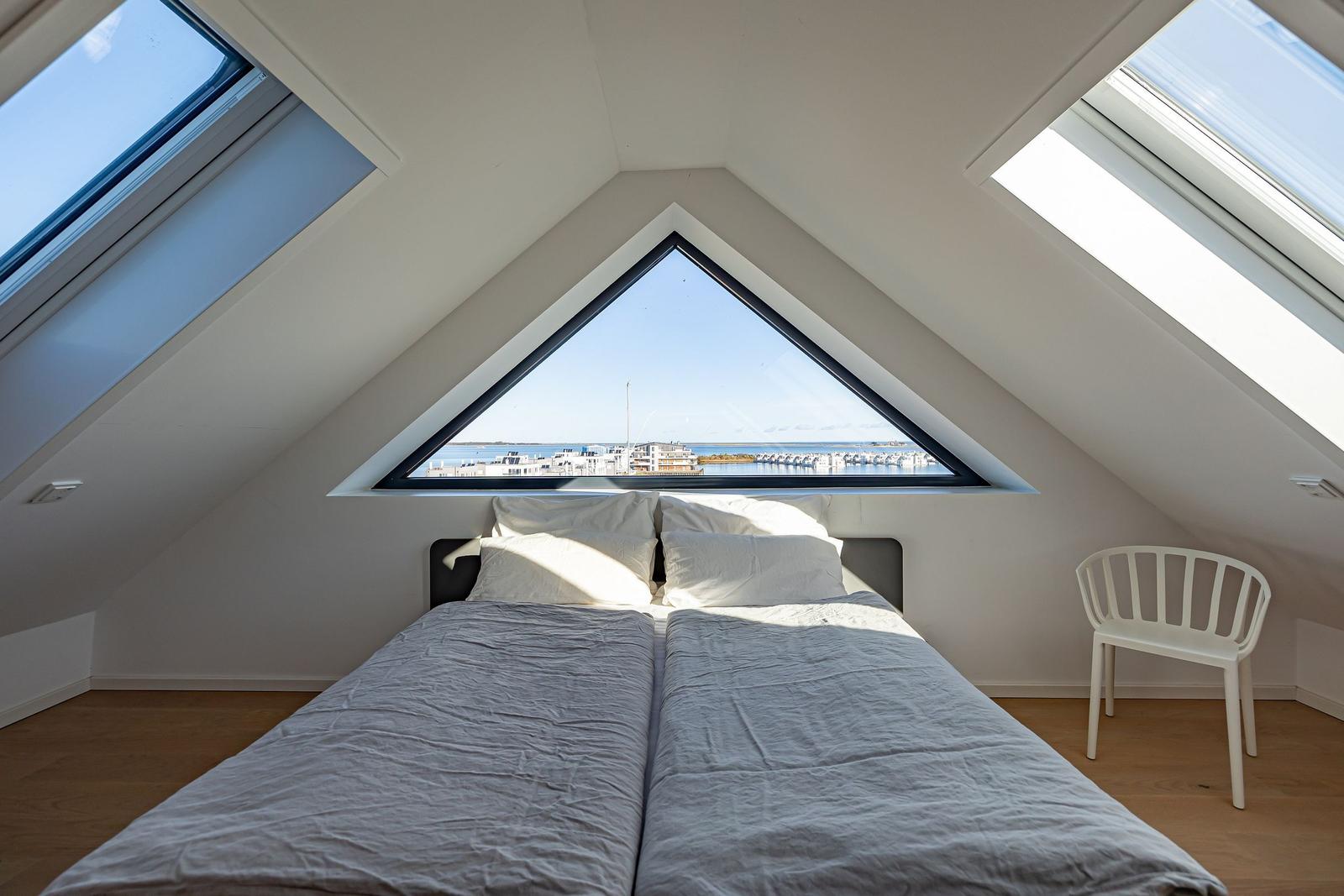 Schlafzimmer mit Dachfenster und Blick auf Hafen
