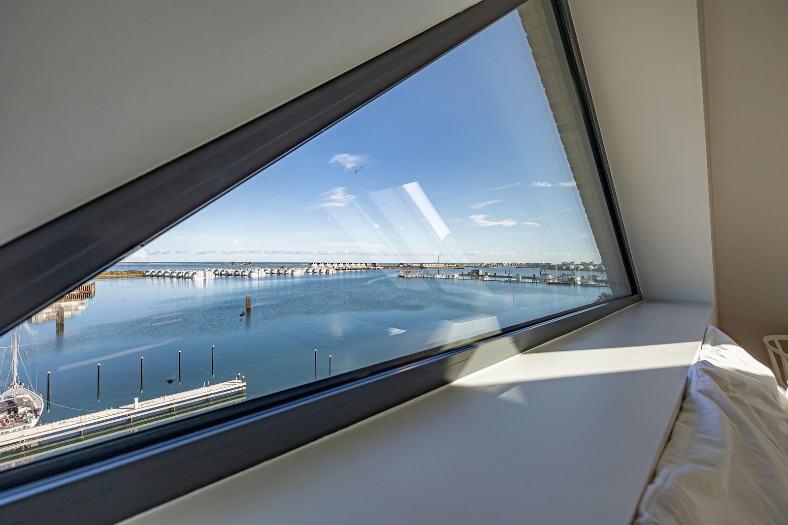 Blick aus dem Schlafzimmer auf den Hafen mit Booten und Wasser.