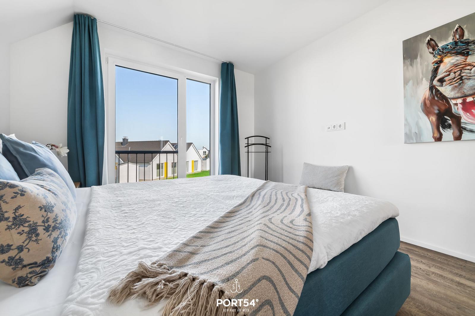 Schlafzimmer mit Bett, Fenster und Wandbild