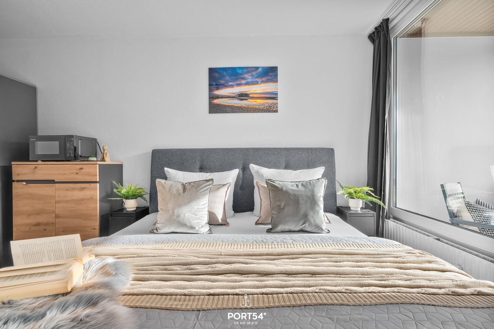 Schlafzimmer mit Bett, Fenster und Wandbild