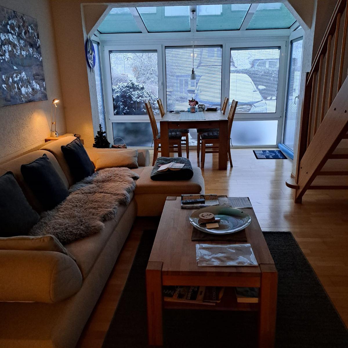 Living and dining area with wooden furniture and glass roof