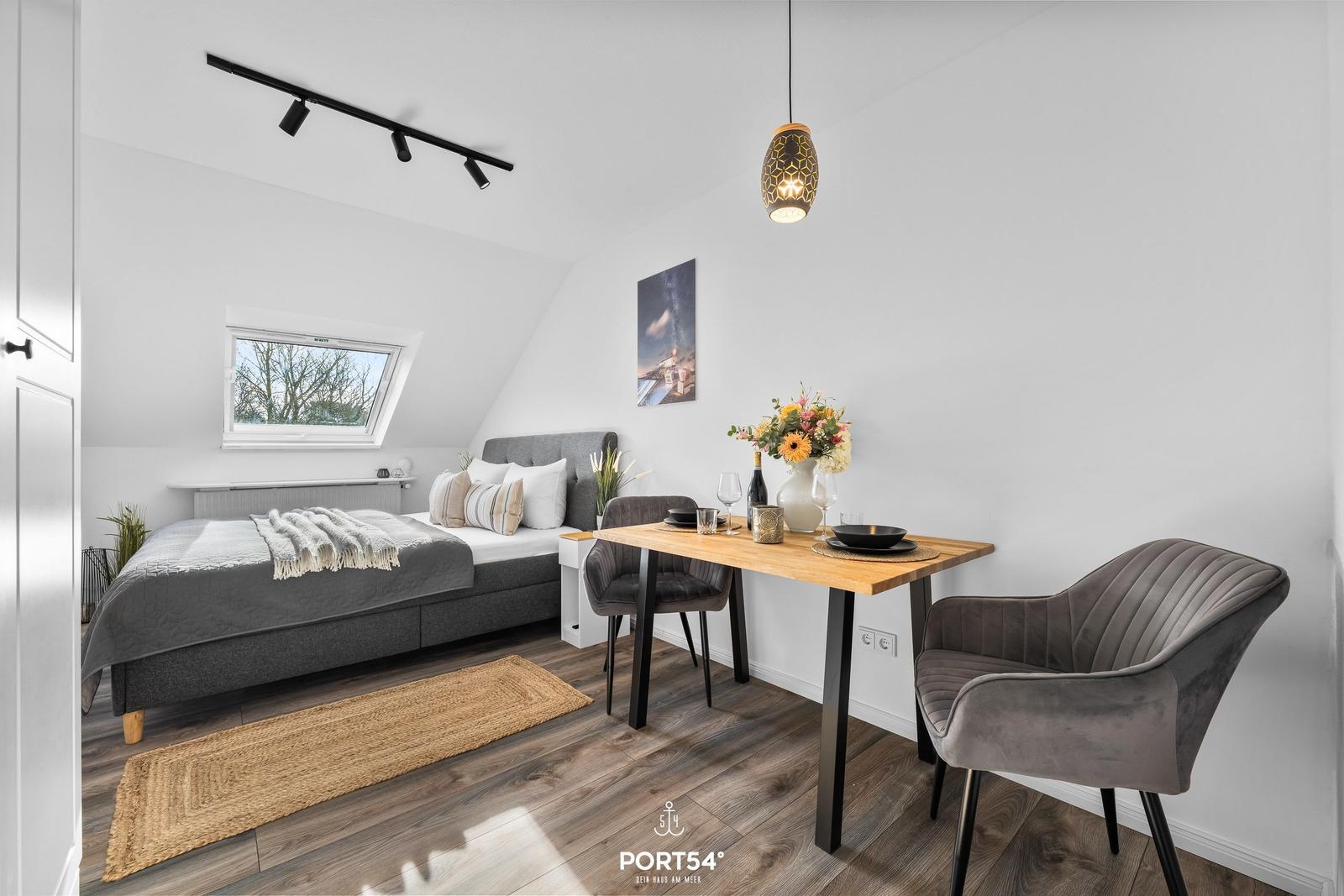 Schlafzimmer mit Doppelbett, Esstisch und Fenster