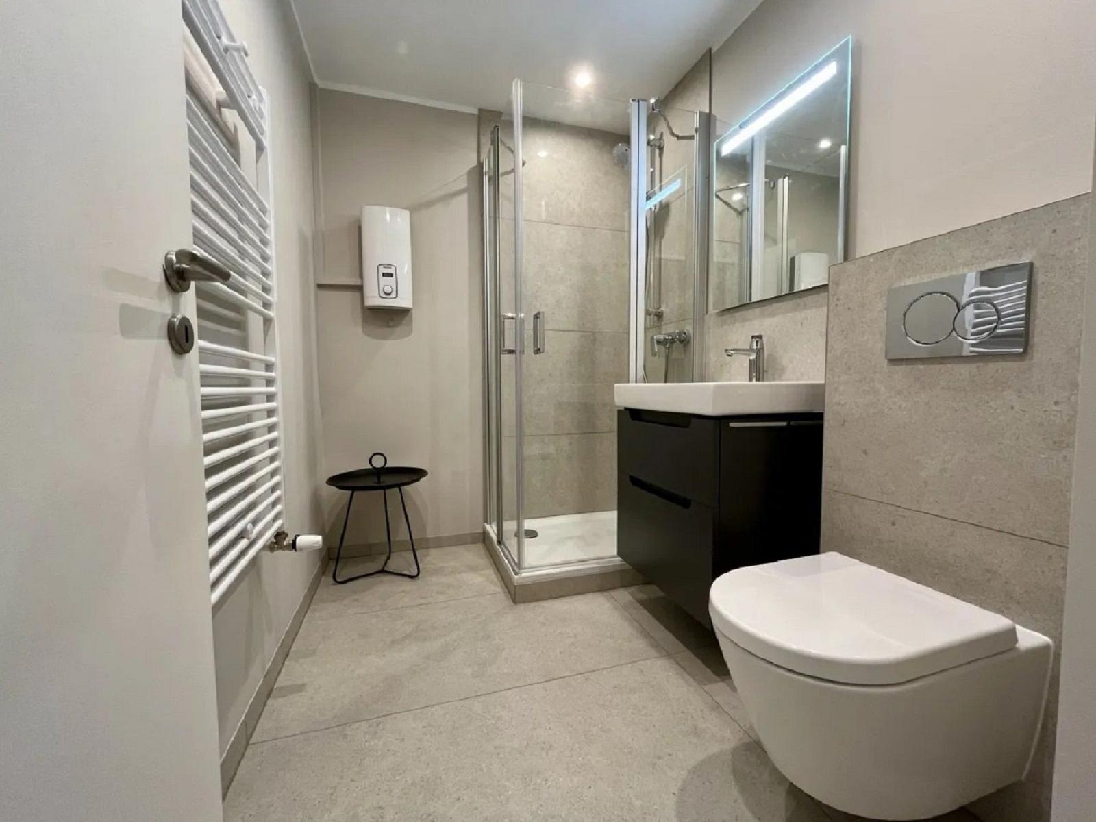 Moderne Badezimmer mit Dusche, Waschbecken und Toilette.