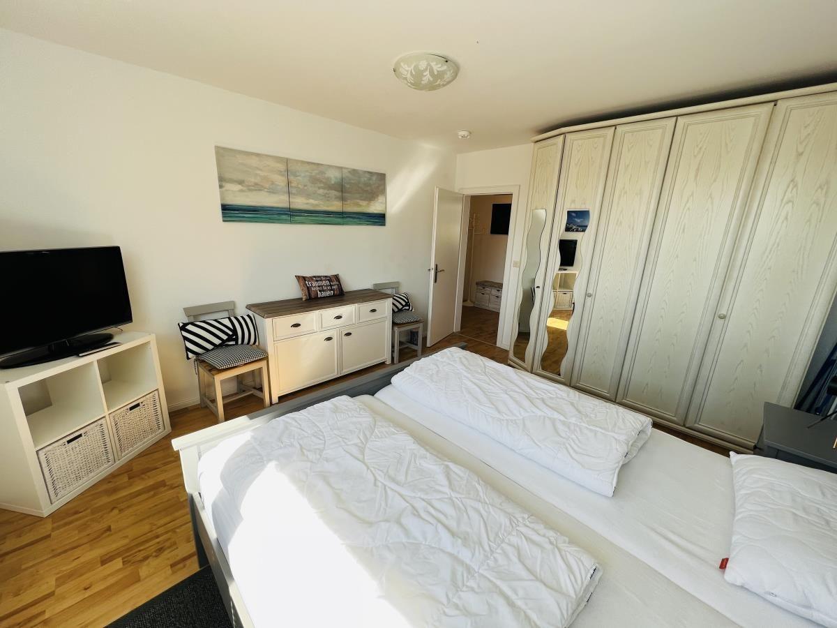 Bedroom with double bed, wardrobe, and TV.