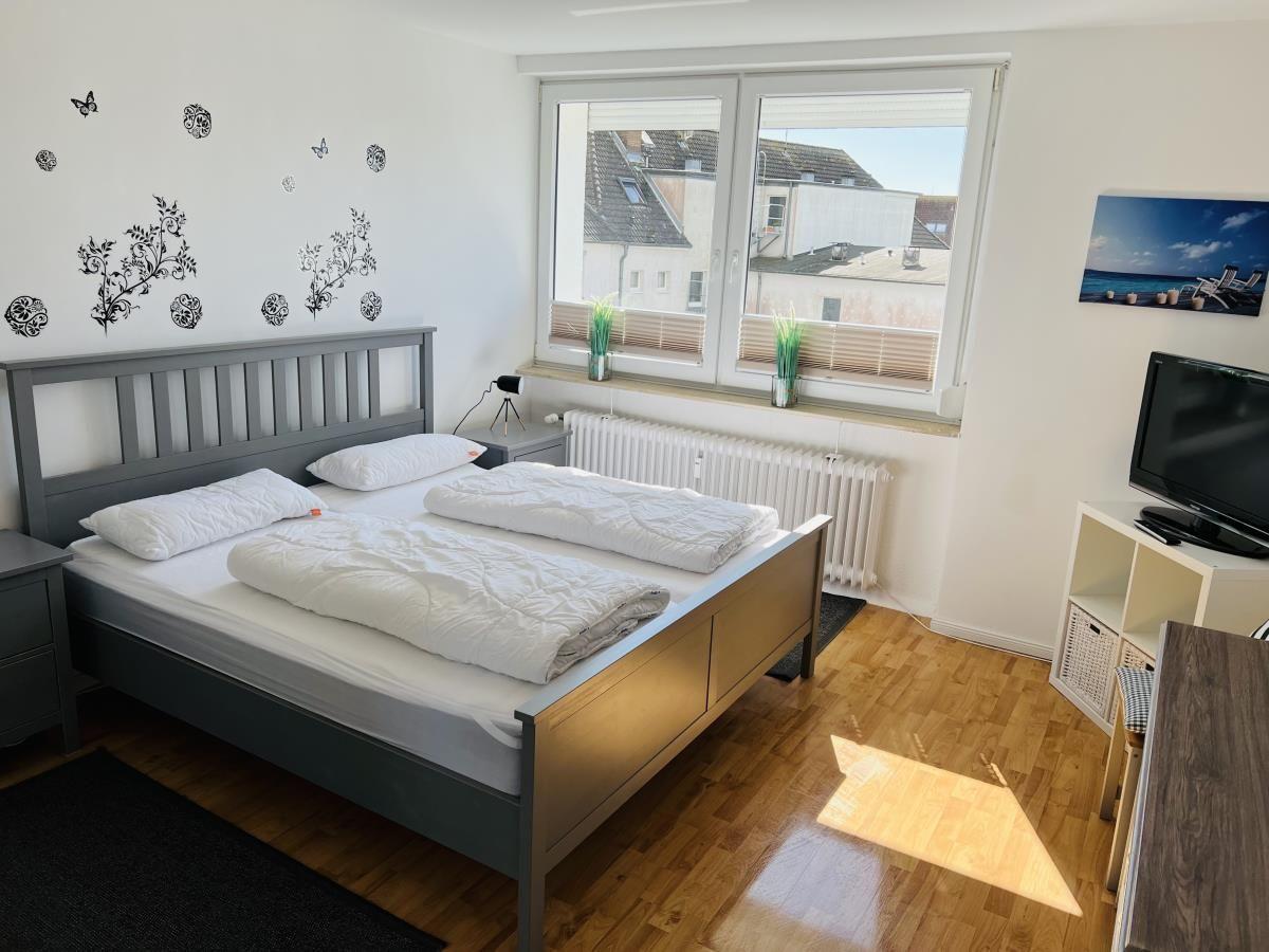 Bedroom with double bed, window, and TV.
