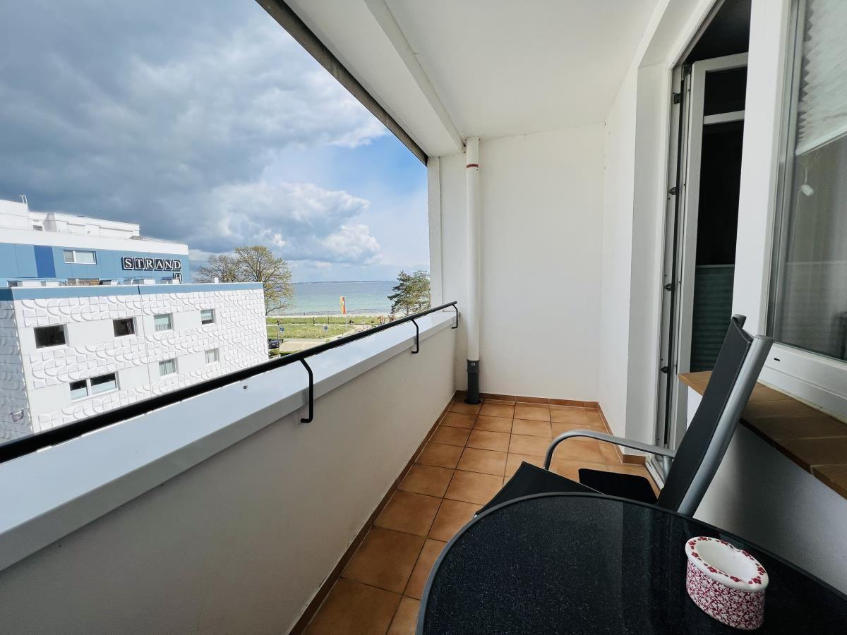 Balcony with table and chair. View of beach and sea.