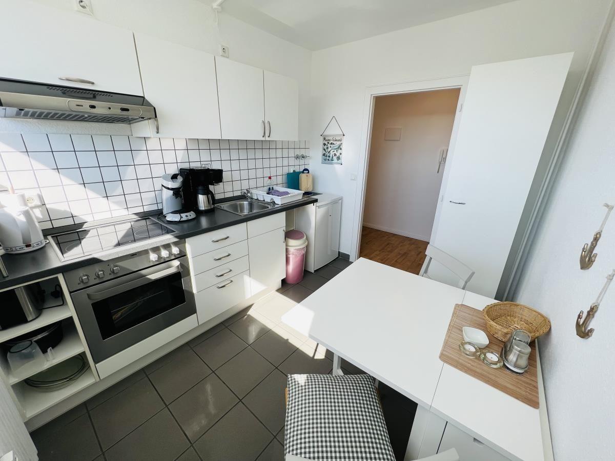 Kitchen with white cabinets, countertop, and dining table.
