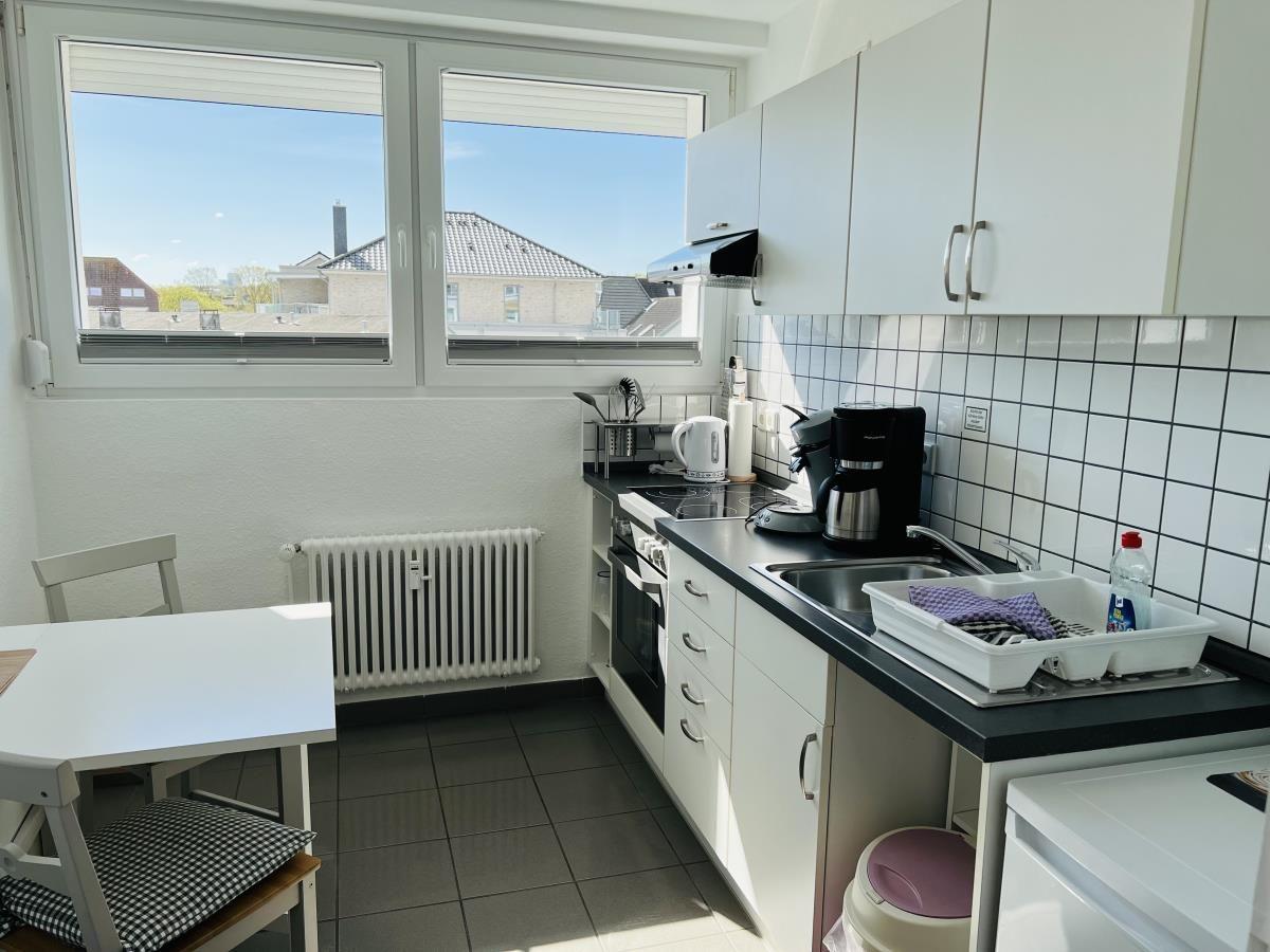 Kitchen with window, worktop, sink, and stove.