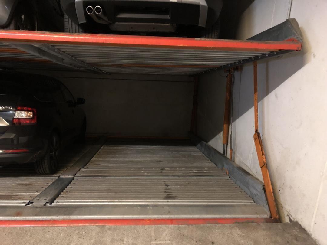 Garage with vehicles and metal floor. Covered parking area.