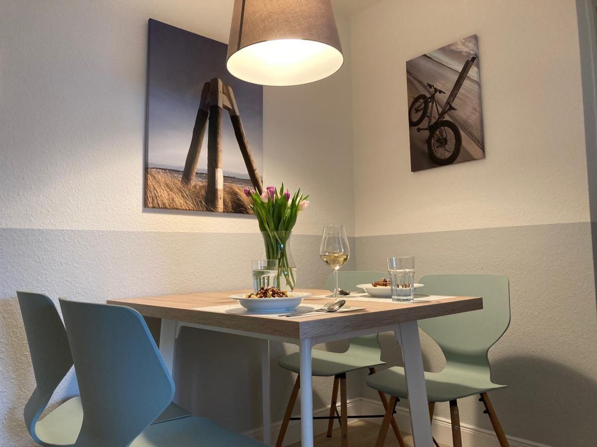 Dining table with chairs, flowers, and wall art on the walls.