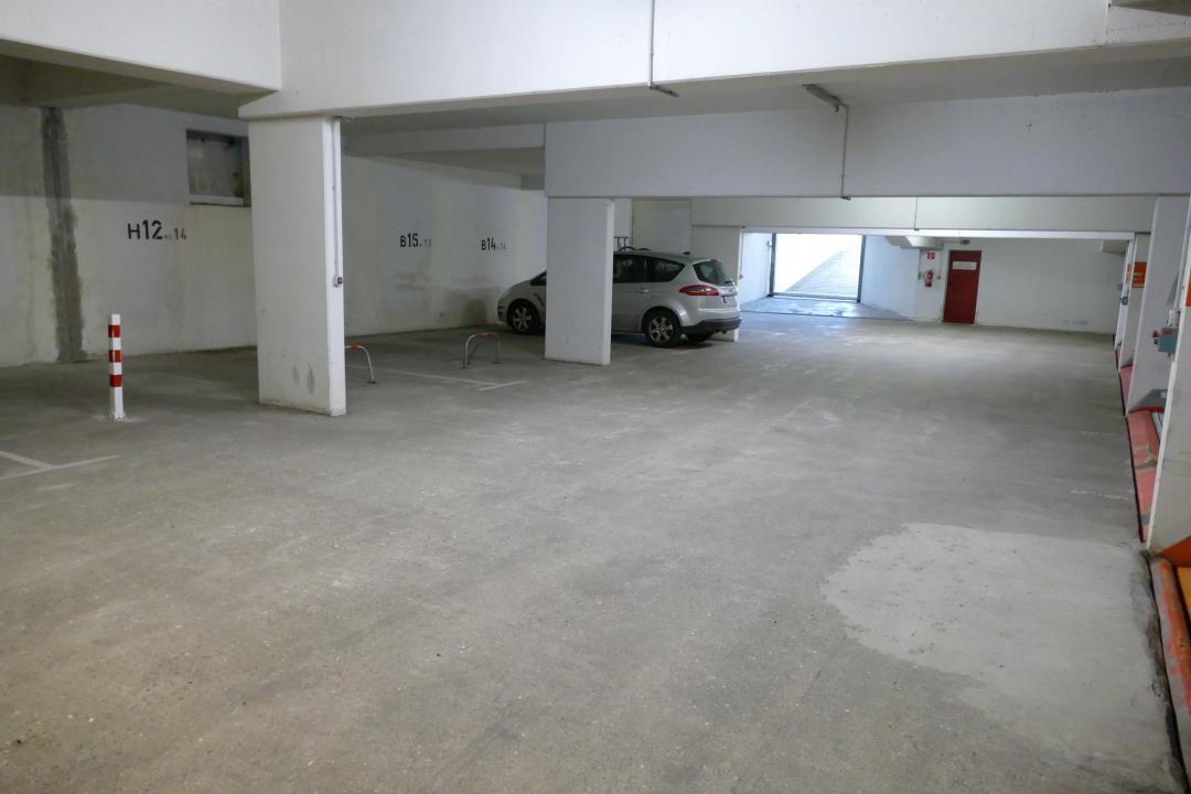 Underground parking lot with one parking space and a red door.