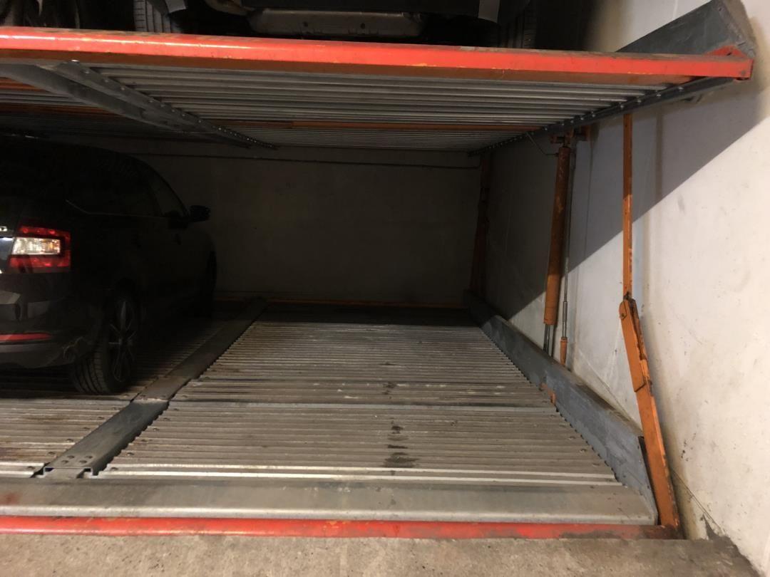 Car parked in a garage with a roll-up door.