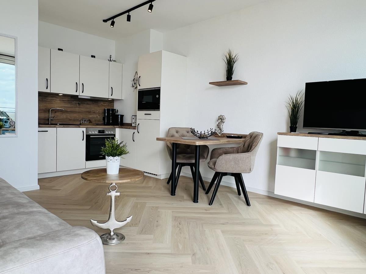 Küche, Essbereich und Wohnbereich mit Holzboden und moderner Einrichtung.