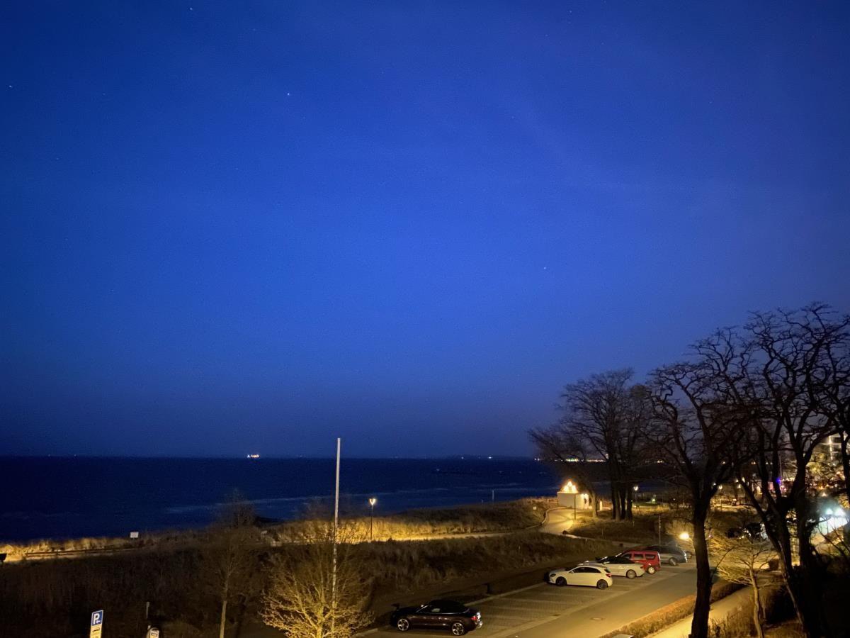 Nachtansicht mit Strand, Parkplatz und sternenklarem Himmel.