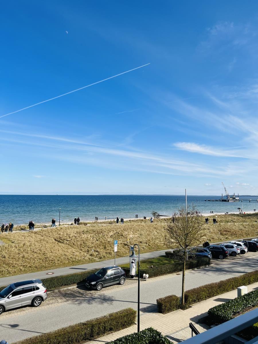 Blick auf Strand, Meer und Parkplatz mit Autos.