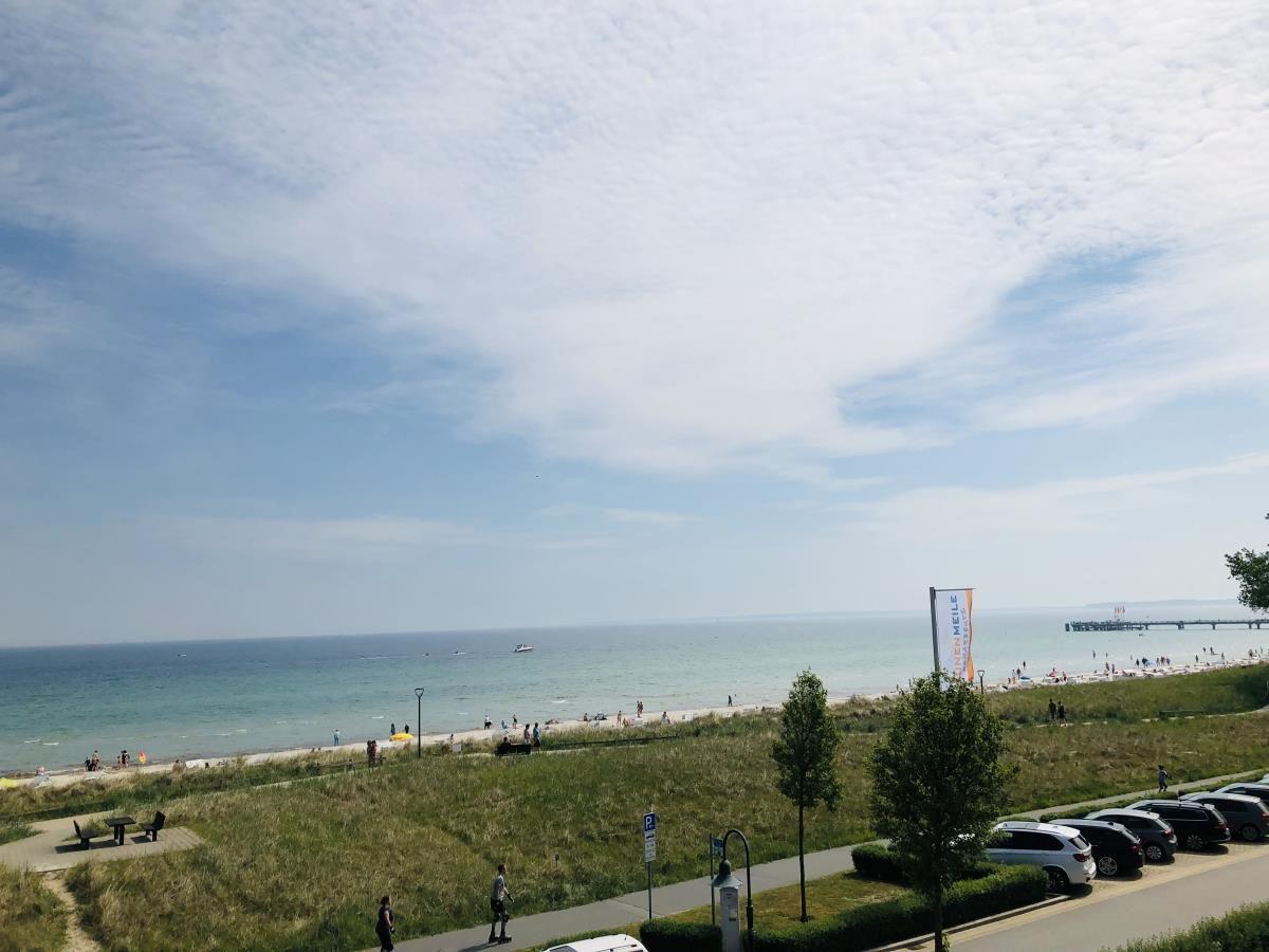 Meerstrand mit Strandpromenade und Parkplatz. Blick auf das Wasser und den Hafen.