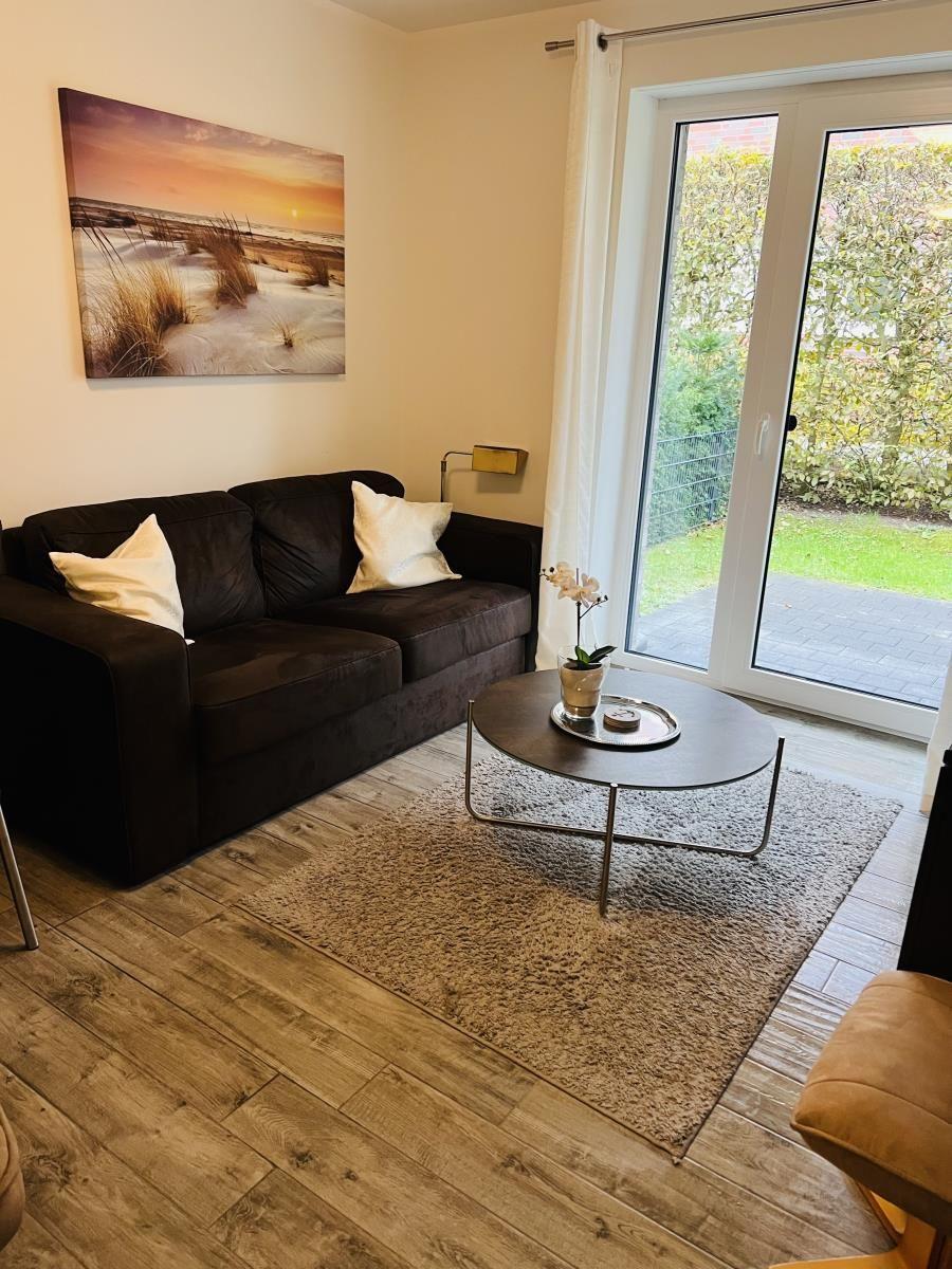Wohnzimmer mit Sofa, Couchtisch und Blick auf den Garten.
