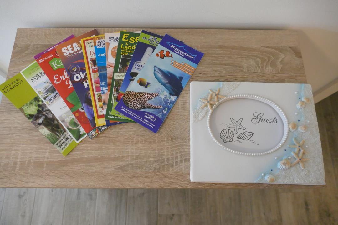 Tisch mit Broschüren und Gästebuch mit Meeresmotiven