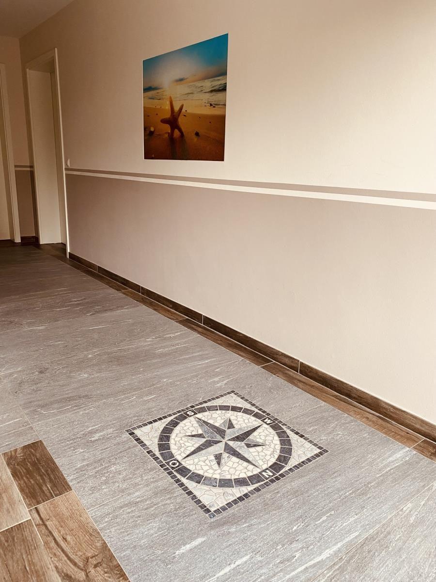 Flur mit Mosaikkompass und Wandbild von Strand