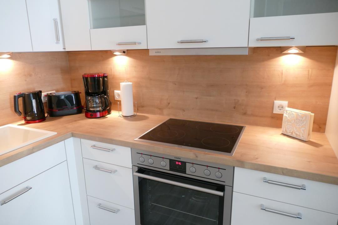 Küche mit weißen Schränken, Holz Arbeitsplatte und Induktionskochfeld.