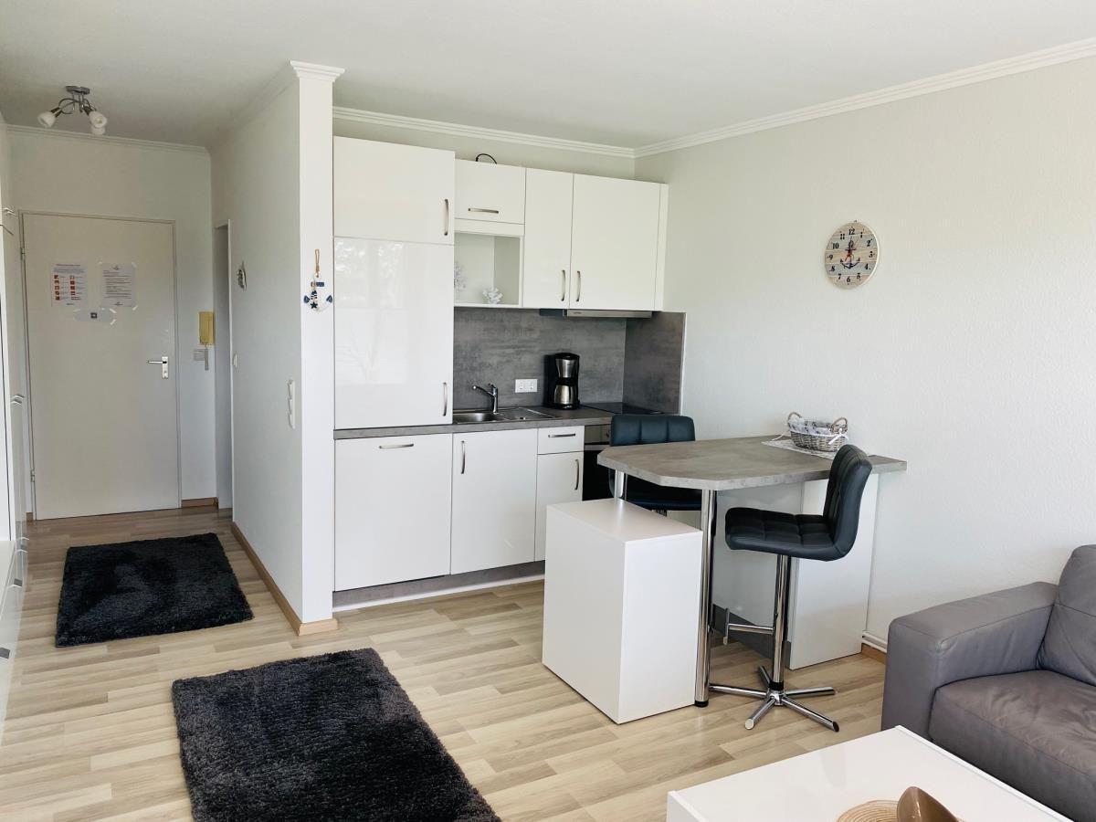 Küche mit Arbeitsplatz, Essbereich und Wohnbereich mit Sofa.
