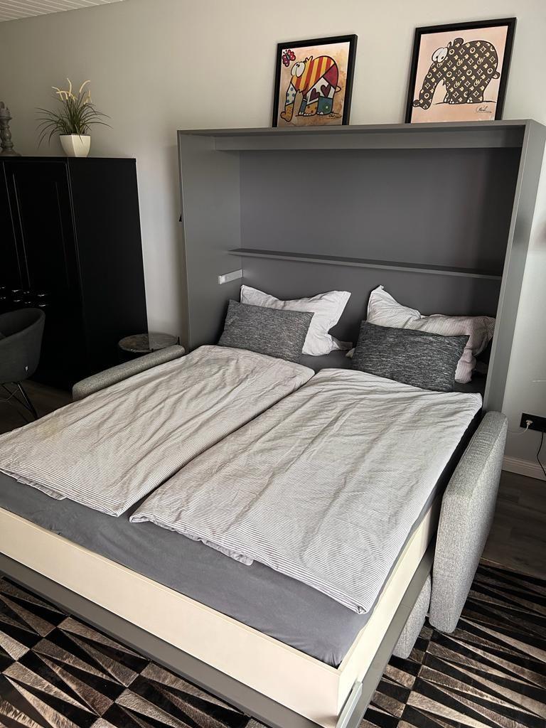 Double bed with gray bedding and wall art above the headboard.