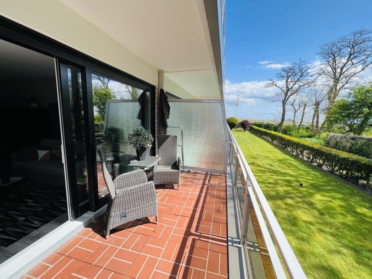 Terrace with seating and view of green lawn.
