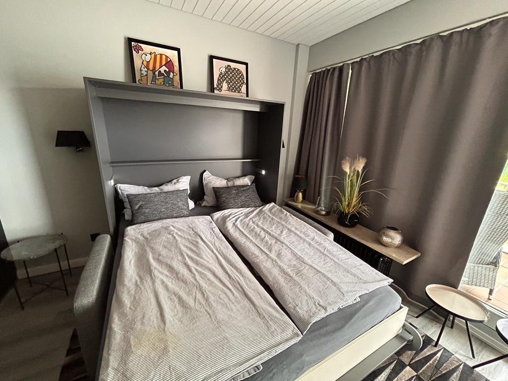 Bedroom with bed, window, and decorative items.