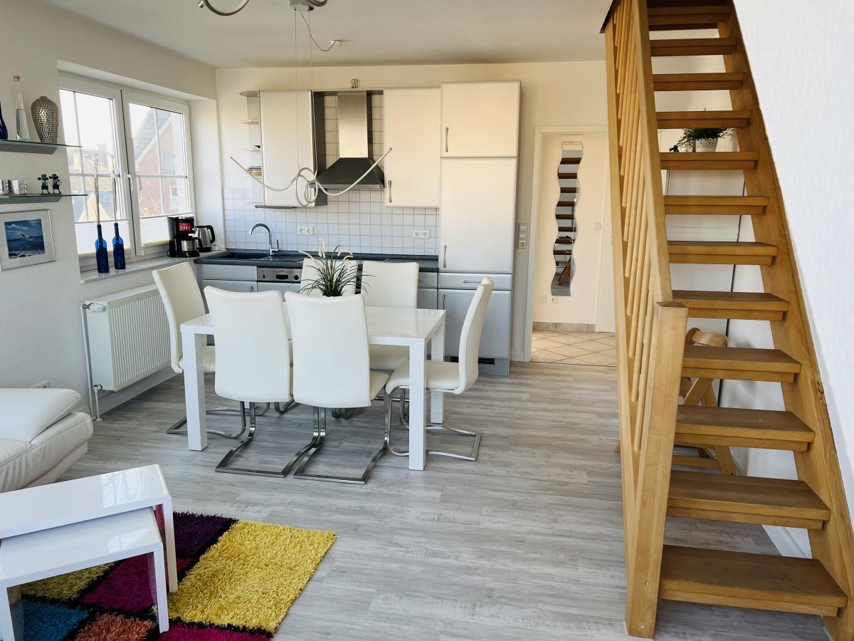 Küche mit Essbereich und Holztreppe zur oberen Etage.