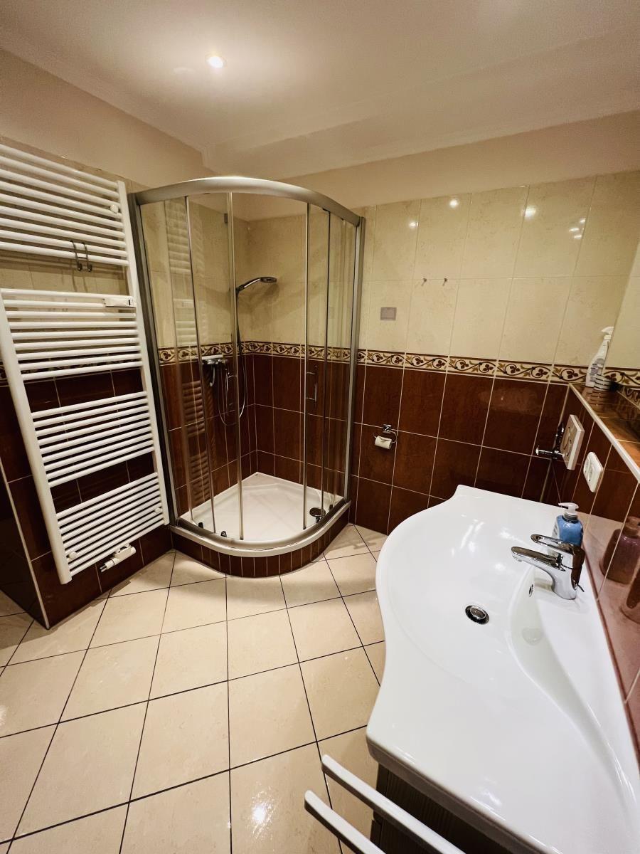 Bad mit Dusche, Waschbecken und Heizkörper
