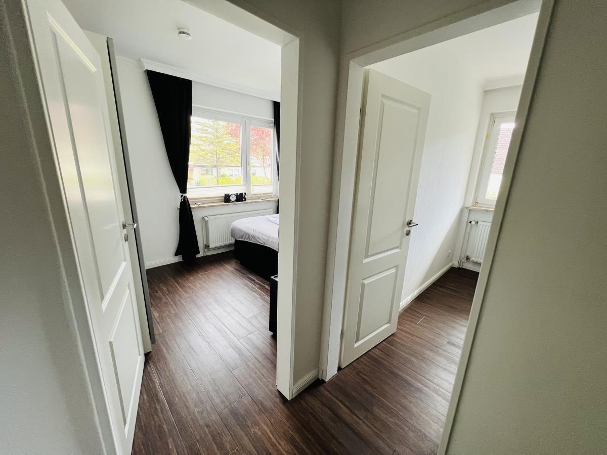 Zwei Schlafzimmer mit Holzboden und Fenstern