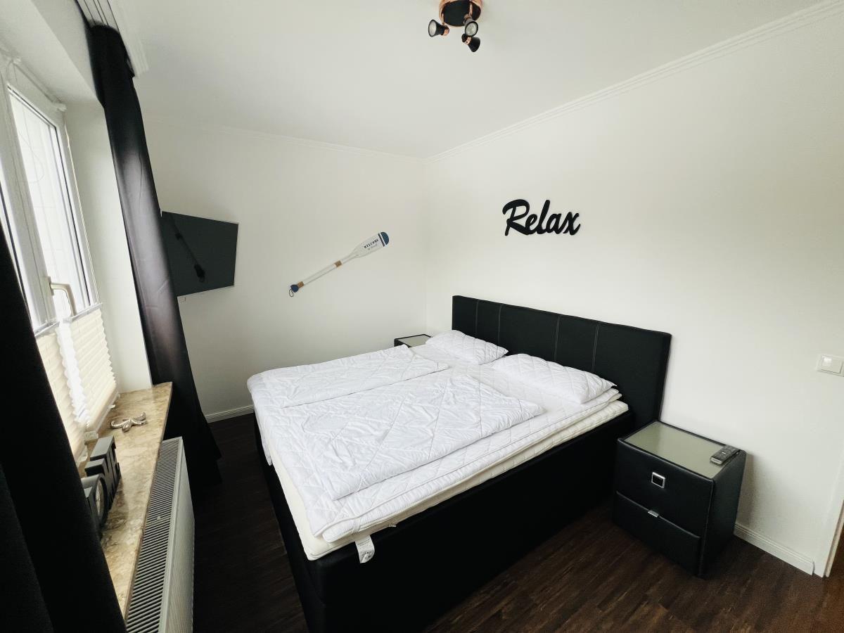 Schlafzimmer mit Doppelbett, Wanddekoration und Fenster