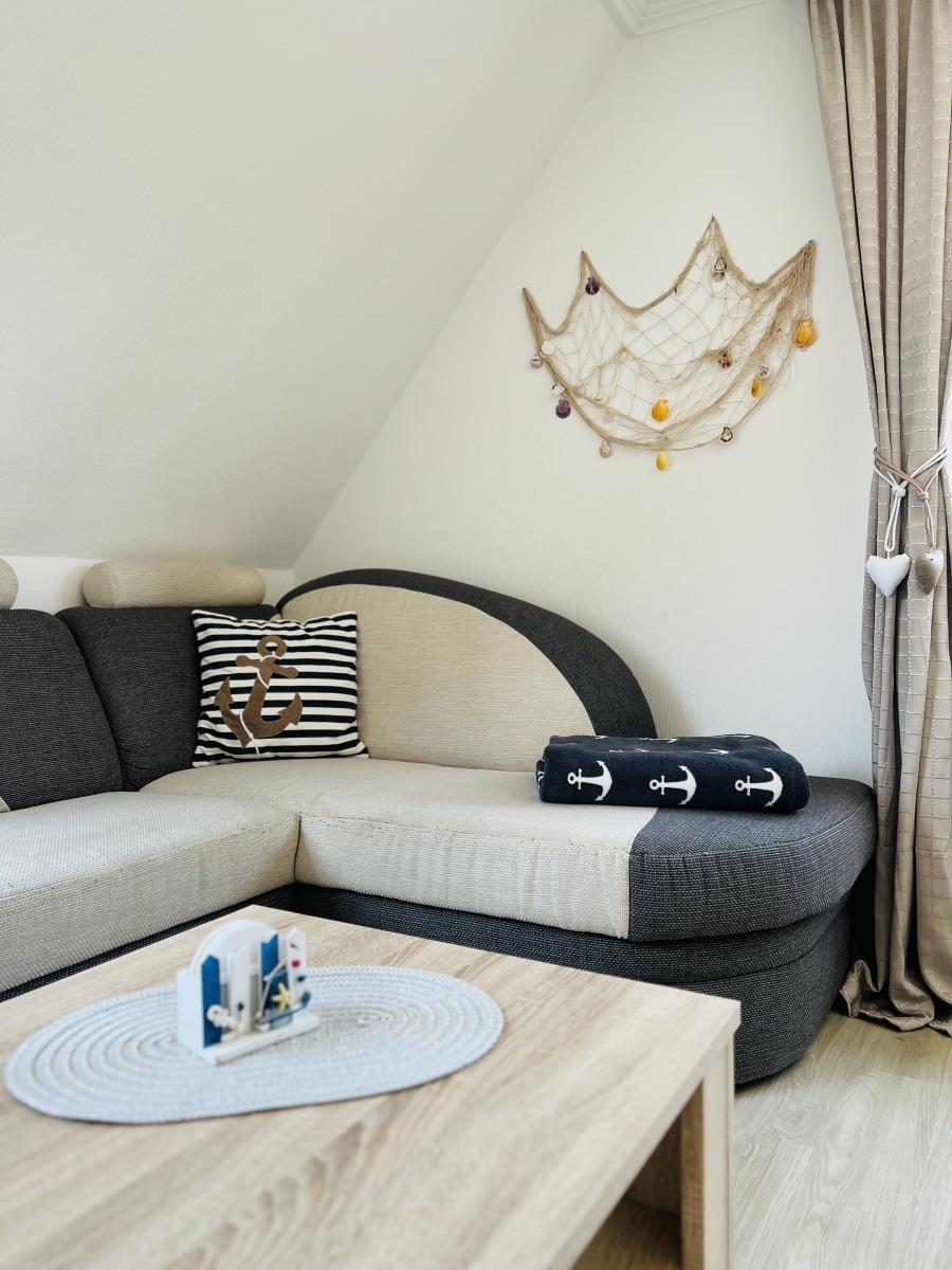 Living room with sofa, table, and wall decoration with fishing net.