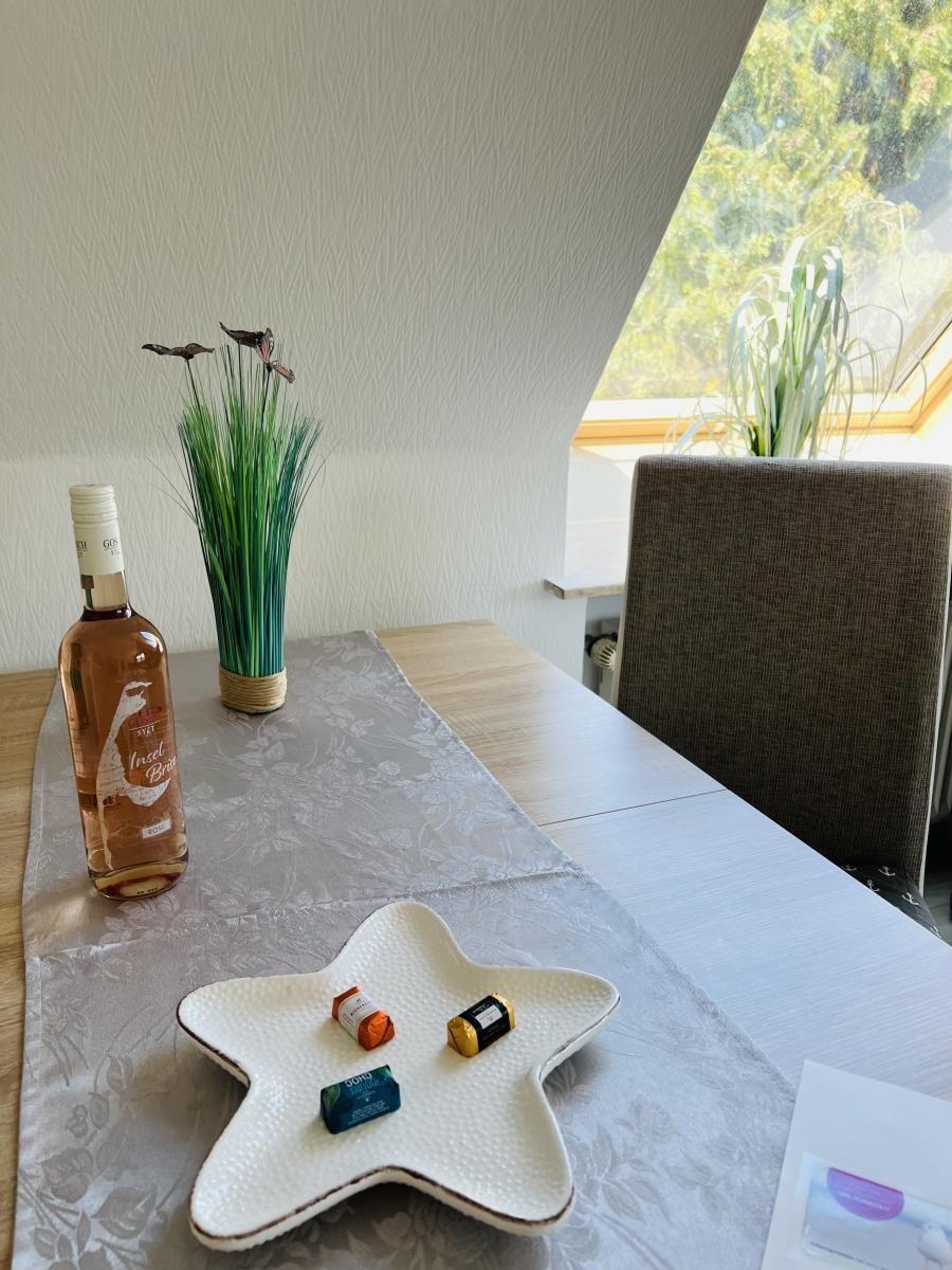 Table with bottle, bowl, and plant by window