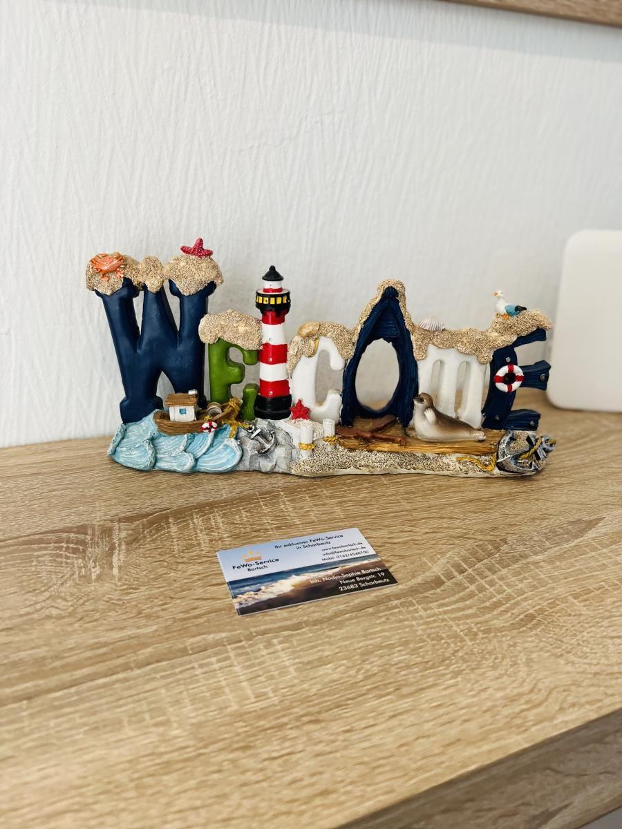Welcome decoration with lighthouse and seal on wooden table