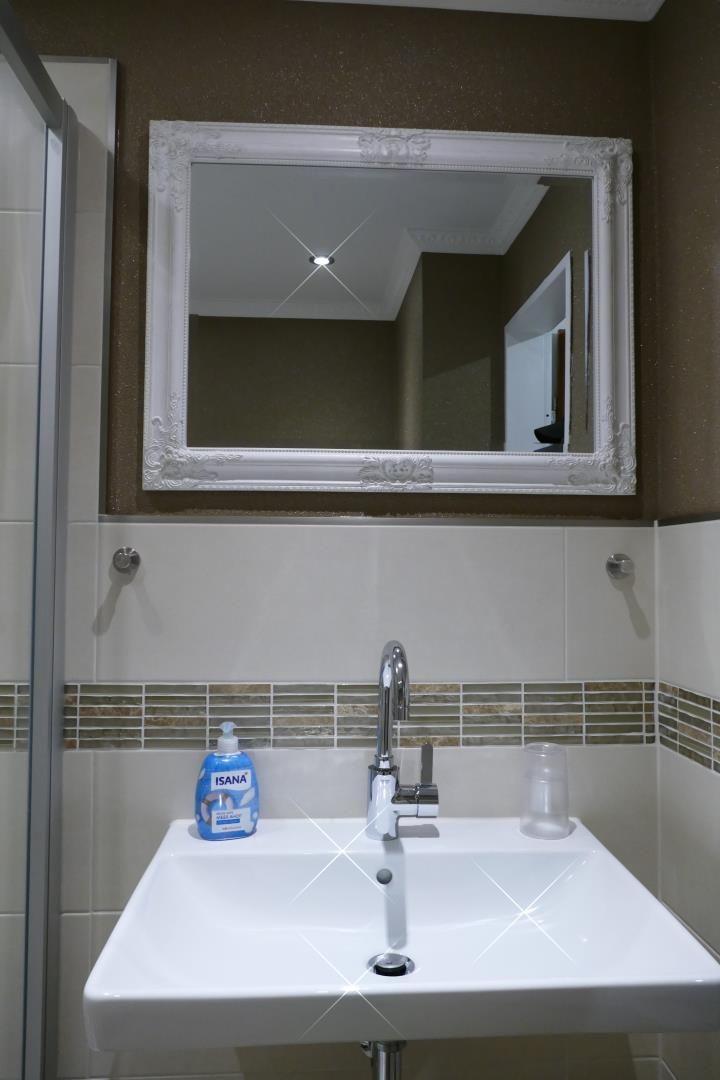 Bathroom with sink, mirror, and shower