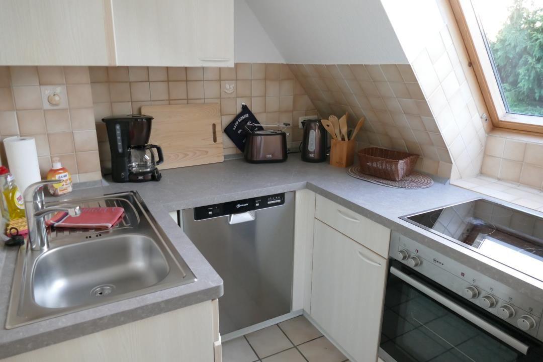 Kitchen with sink, dishwasher, stove, and oven under sloped roof