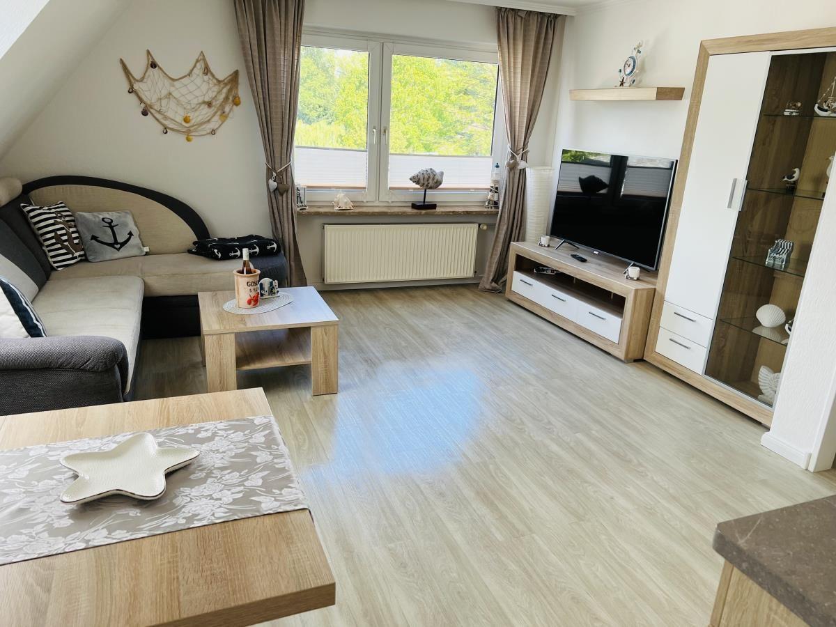 Living room with sofa, TV, and window to the garden.