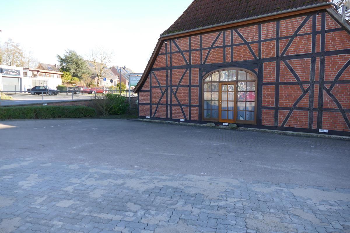 Fassade eines Backsteinhauses mit Fachwerk und Bogenfenster