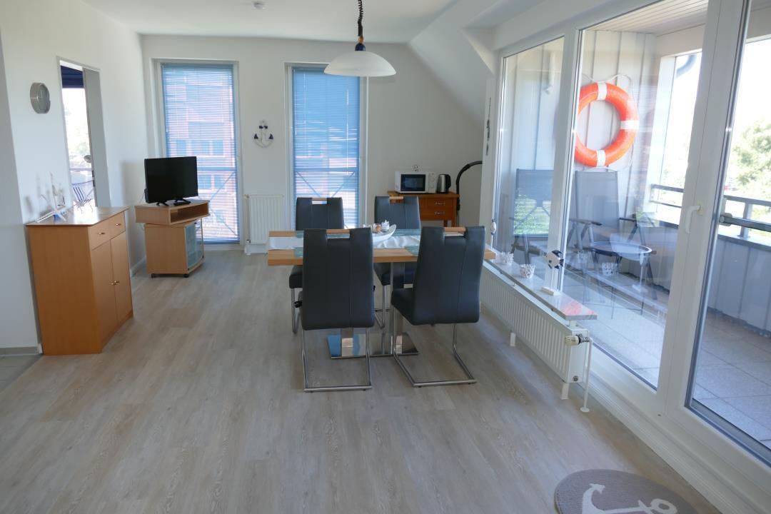 Dining room with table, chairs, and glass doors to terrace.