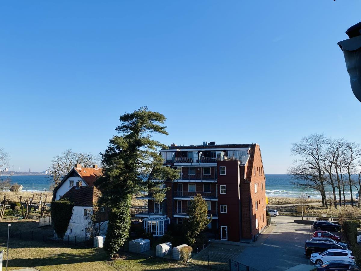 Red multi-family house with sea view and parking lot.