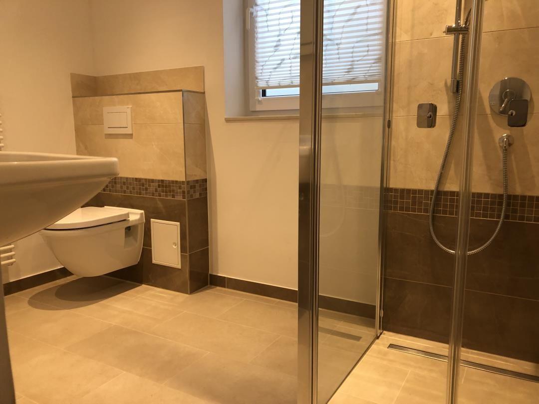 Badezimmer mit Dusche, Toilette und Waschbecken