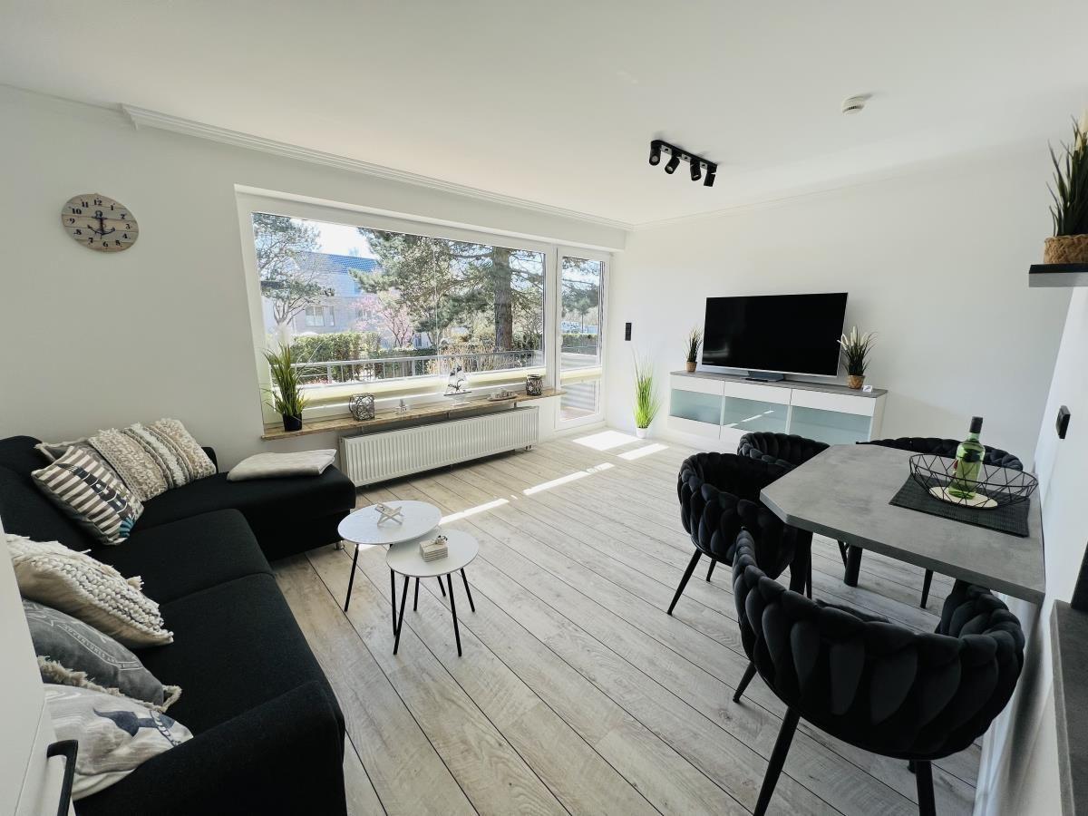 Living and dining area with sofa, dining table, and TV.